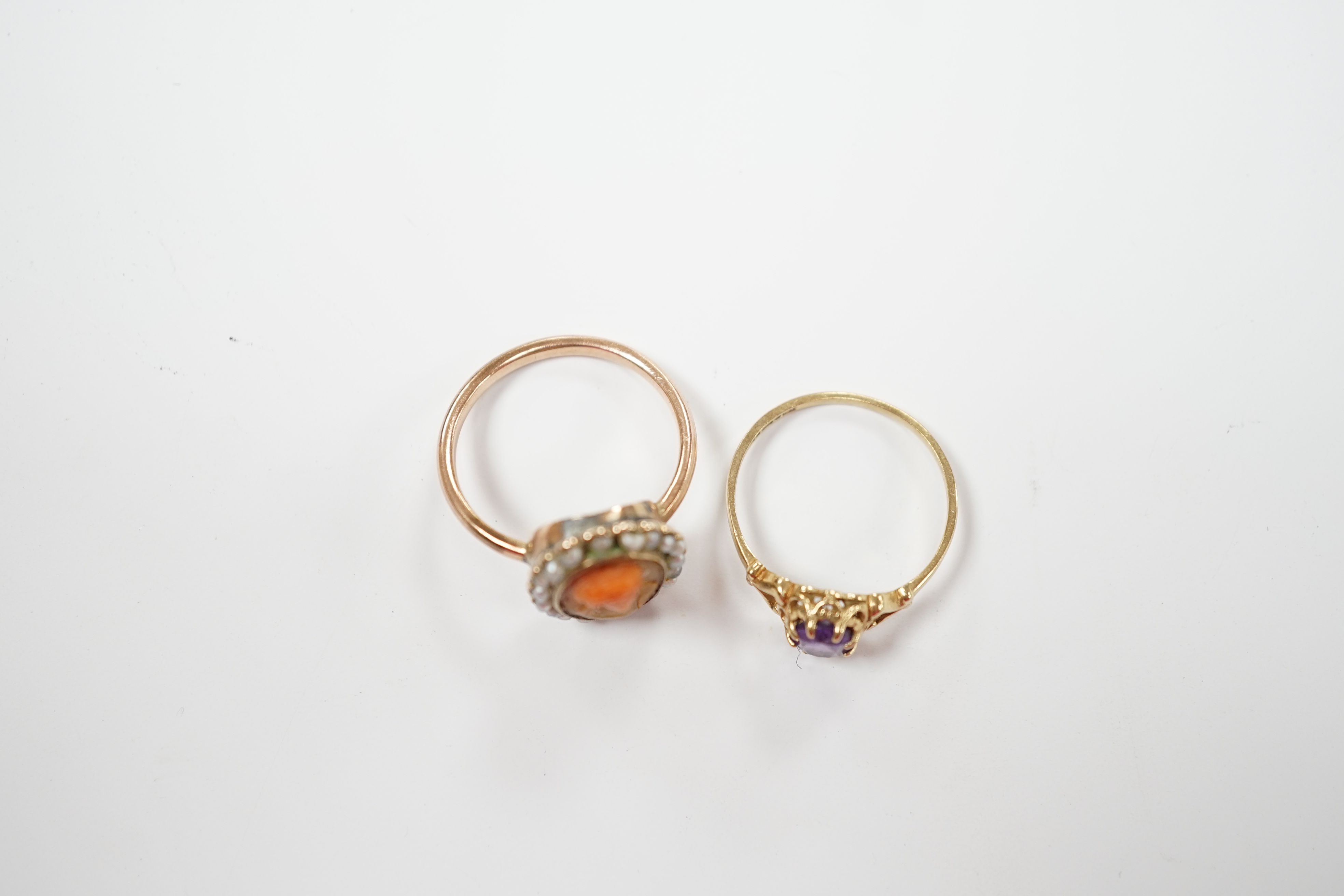 A modern 9ct gold and single stone amethyst set ring and a yellow metal, carved coral and split pearl set ring.